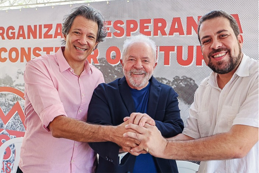 Foto em que Haddad, Lula e Boulos dão-se as mãos