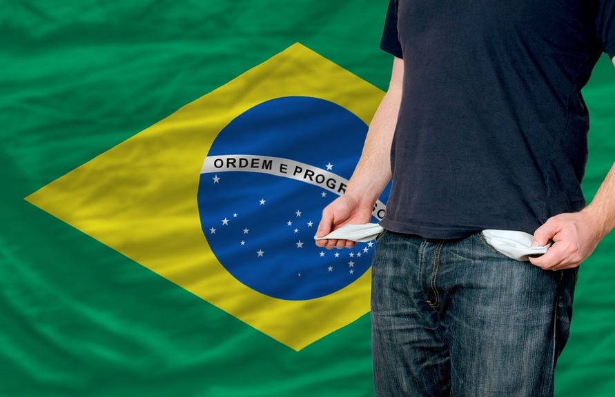 Cidadão mostra os bolso vazios. Ao fundo a bandeira brasileira detornada