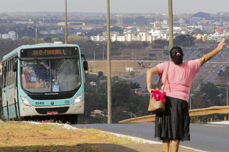 Mulher estende o braço para parar o ônibus