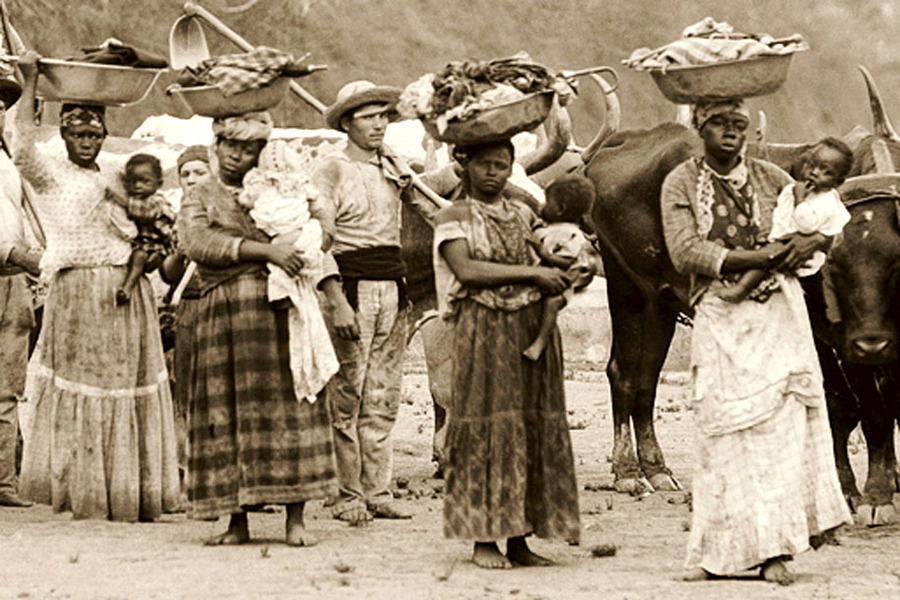 Foto em que mostra um grupo de escravos negros e, junto deles, um branco.