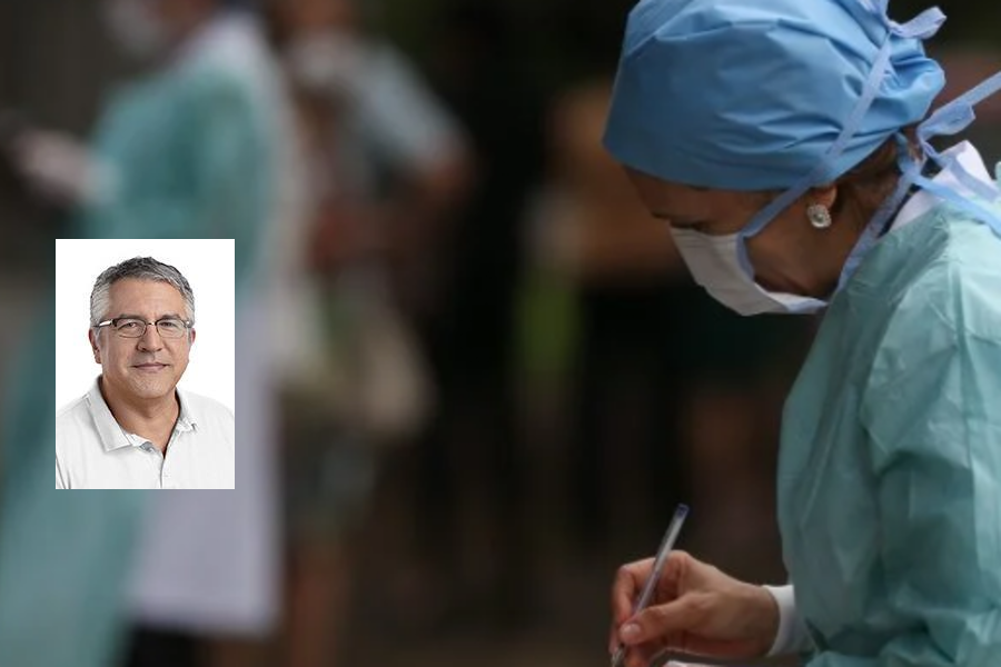 Foto de enfermeira, com máscara, de cabeça baixa escrevendo em um bloquinho