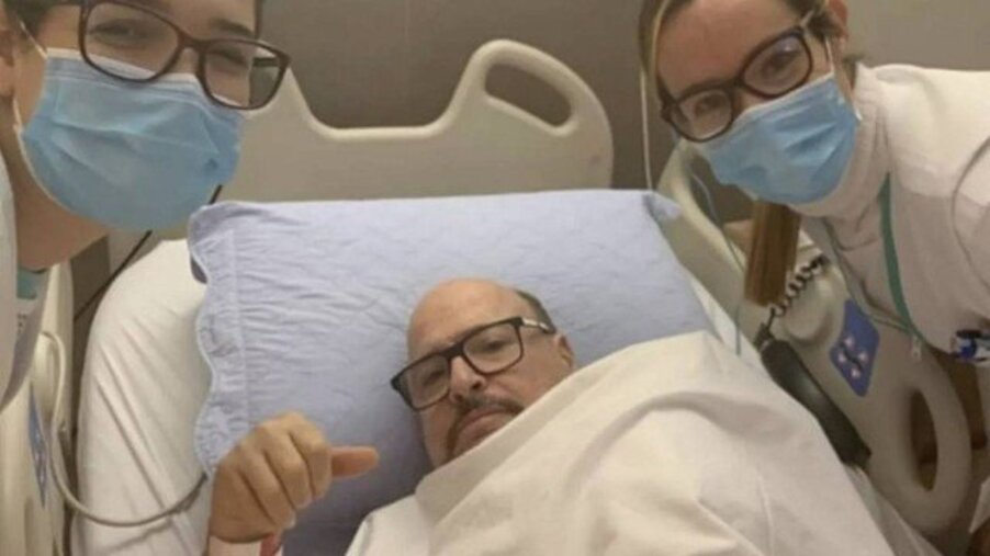 Foto de Paulinho no leito do Hospital acompanhado de duas enfermeiras