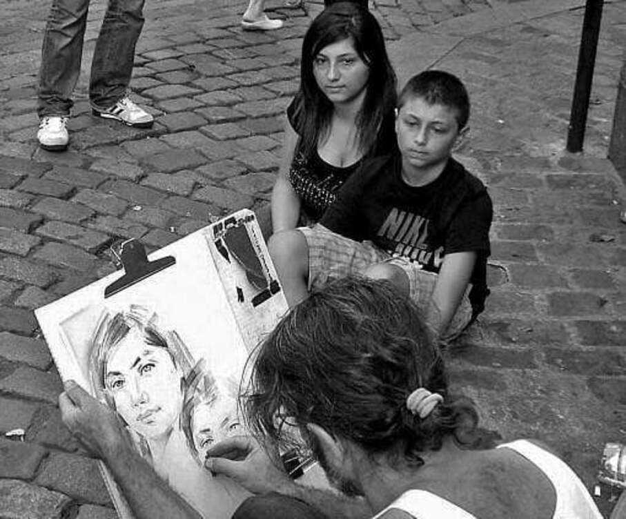 Artista desenha na prancheta o retrato de uma mulher e de uma criança