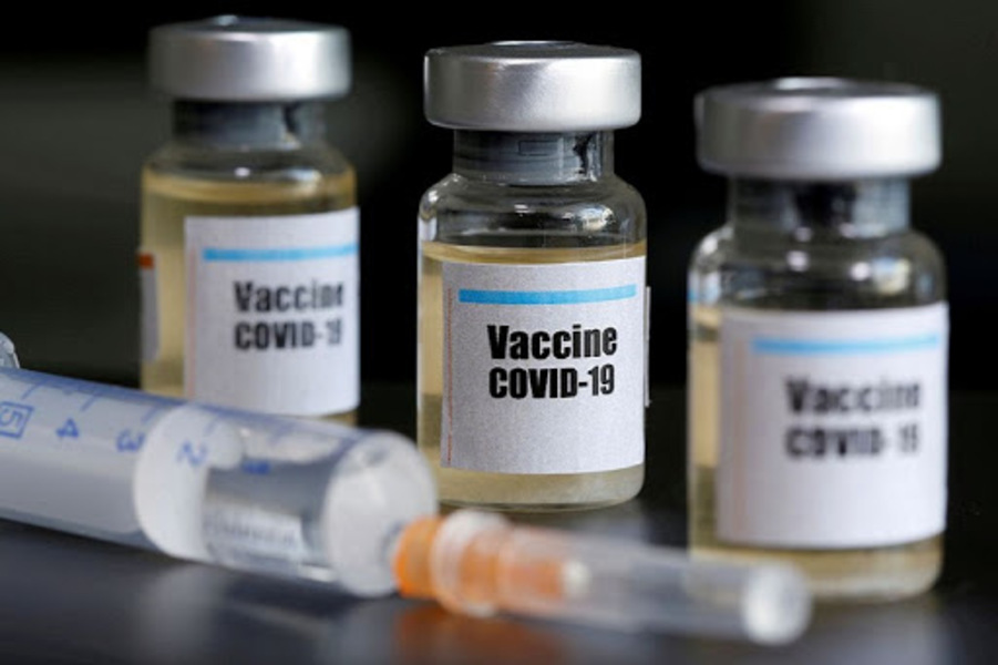 Imagem de um frasco de vacina com seringa sobre a mesa