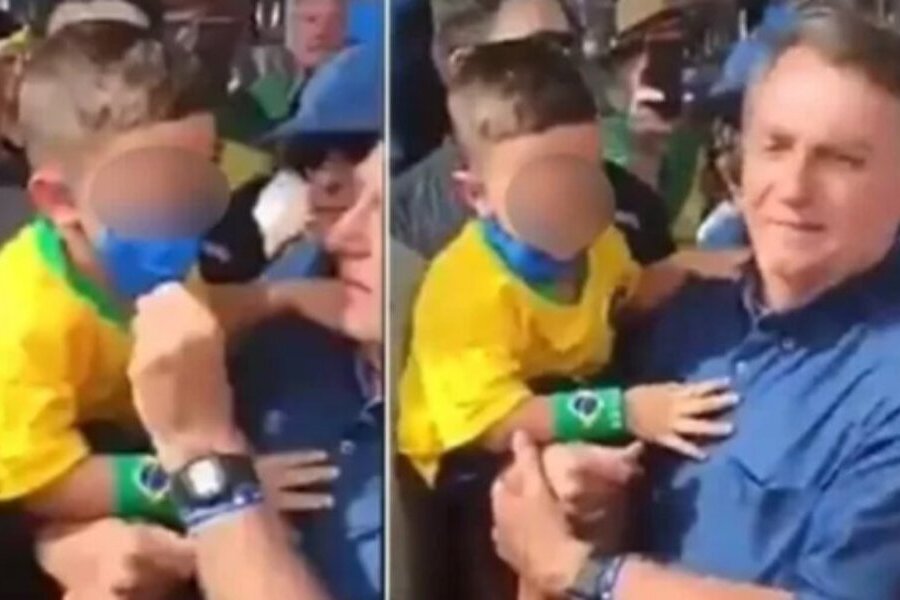 Em meio a uma aglomeração, Bolsonaro segura uma criança no colo e retira a máscara dela.