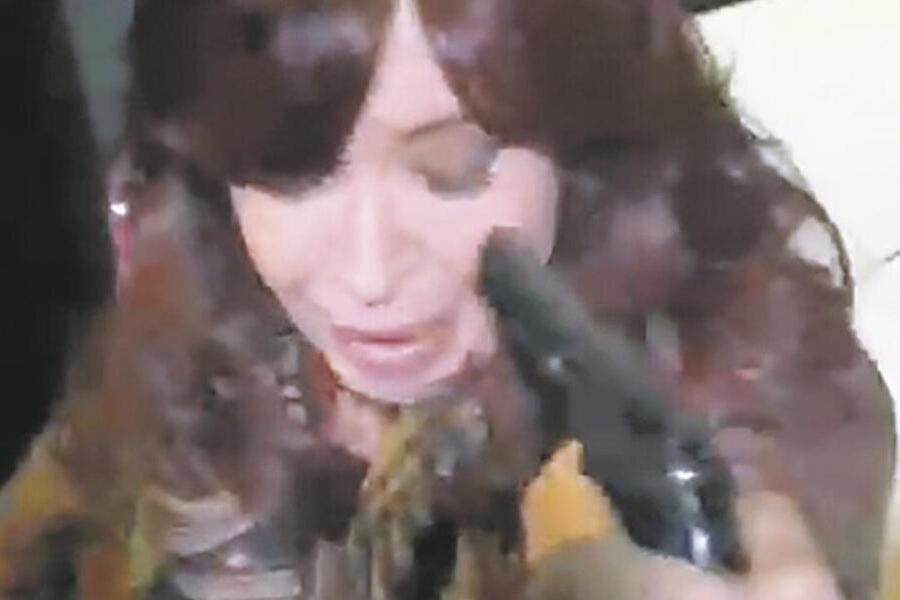 Imagem de celular em que um homem aponta um revólver para a cabeça de Cristina Kirchner
