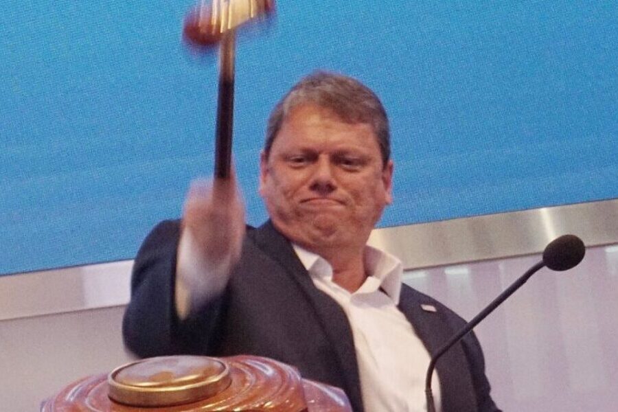 Foto do governador Tarcísio de Freitas batendo o martelo da privatização com raiva