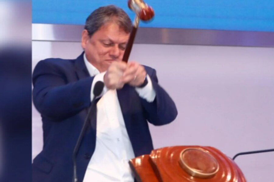 Foto do governador de São Paulo, Tarcísio de Freitas, batendo com muita força o martelo que simboliza o pregões da Bolsa de Valores