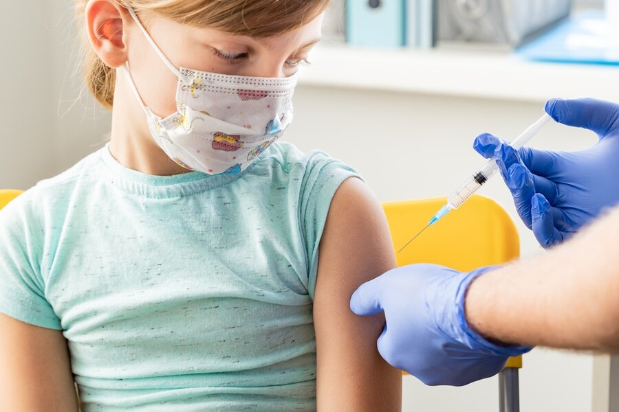 Foto de criança recebendo vacina no braço esquerdo
