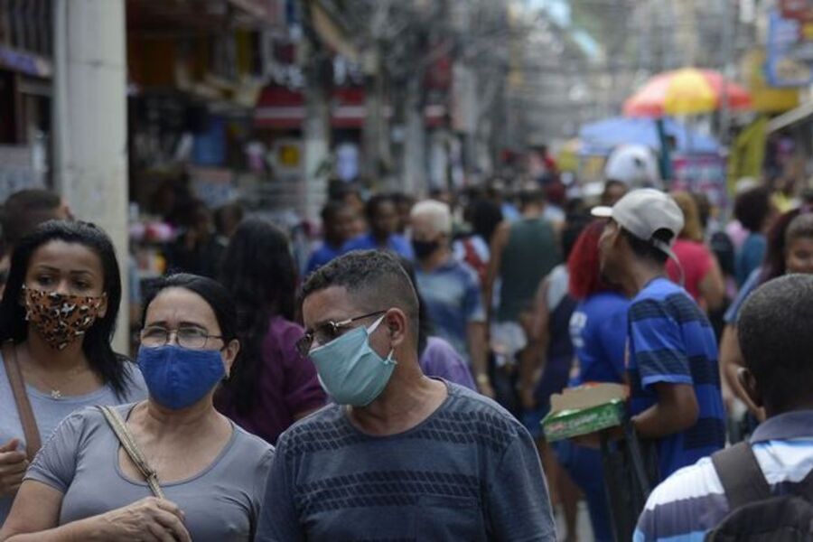 Multidão nas ruas de SP andando de máscaras contra a Covid-19