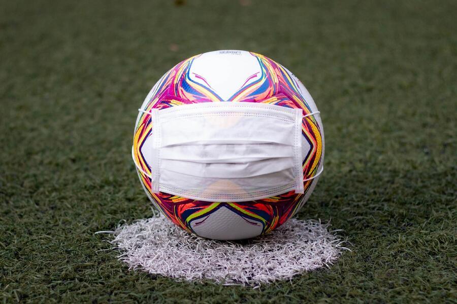 Foto de uma bola de futebol usando uma máscara protetora contra o coronavírus