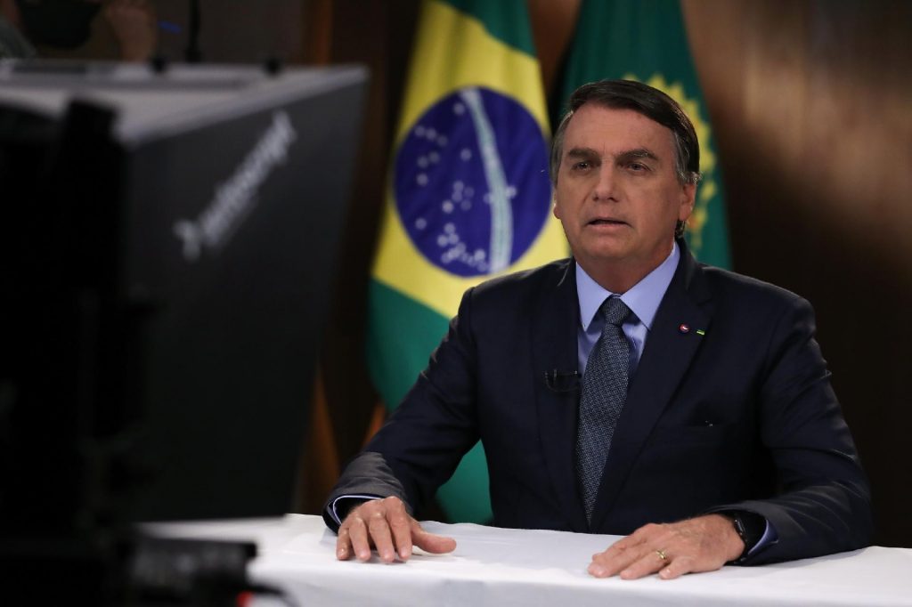 Bolsonaro sentando a uma mesa lê seu discurso para Assembleia Geral da ONU