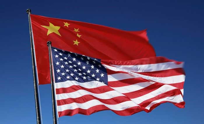 Foto das bandeiras da China (ao fundo) e dos EUA (em primeiro plano)