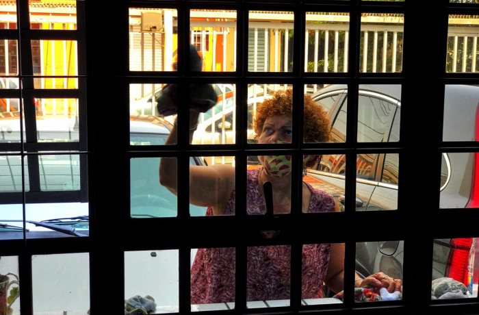 Empregada doméstica limpa o vidro da janela