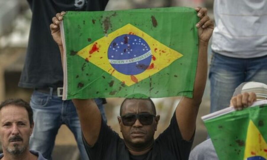 foto de uma criança nega em primeiro plano e a bandeira do Brasil ao fundo