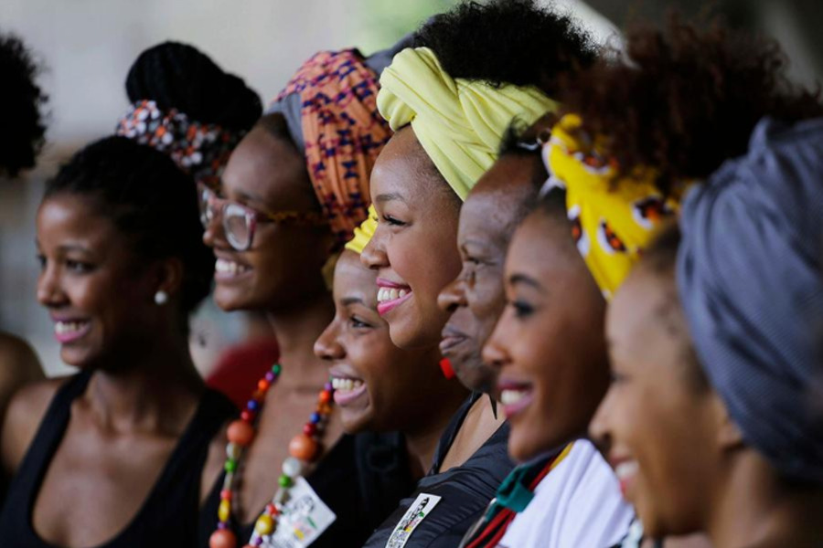 Mulheres negras sorrindo, de perfil.