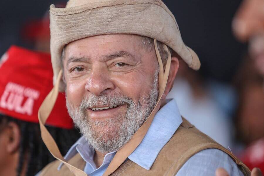 Foto em close up de Lula com o típico chapéu nordestino. Ele está sorrindo