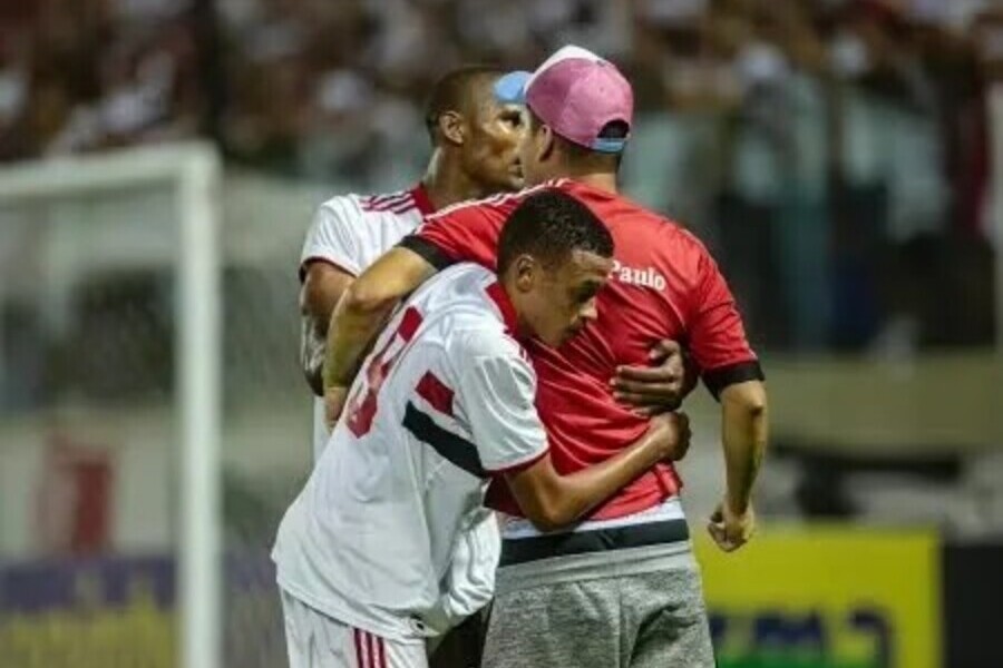 foto que mostra o jogador do São Paulo, Caio Matheus, sub-20, contendo um torcedor que acabou de invadir o campo para agredir um jogador do Palmeiras