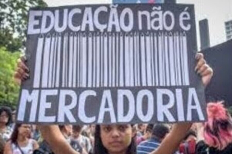 Aluna ergue um cartaz escrito "Educação não é Mercadoria"