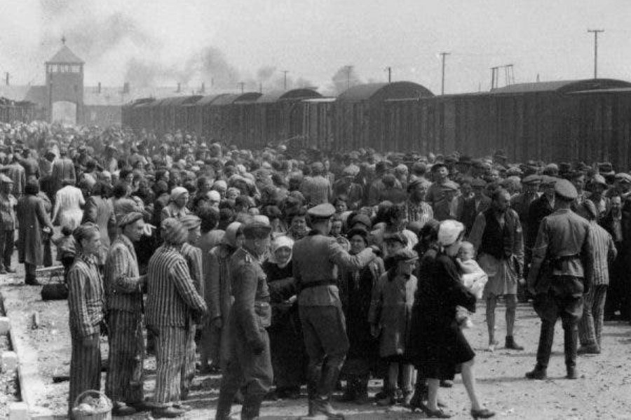 Uma multidão de judeus e outros presos embarcam em um trem com destino ao campo de concetração