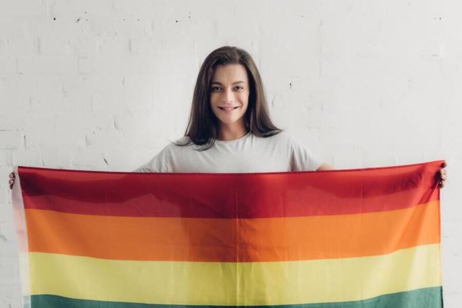 Mulher travesti estende bandeira LGBTQIA+