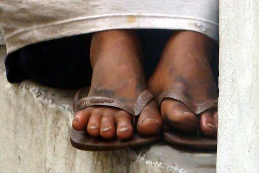 Foto dos pés de uma criança em situação de rua