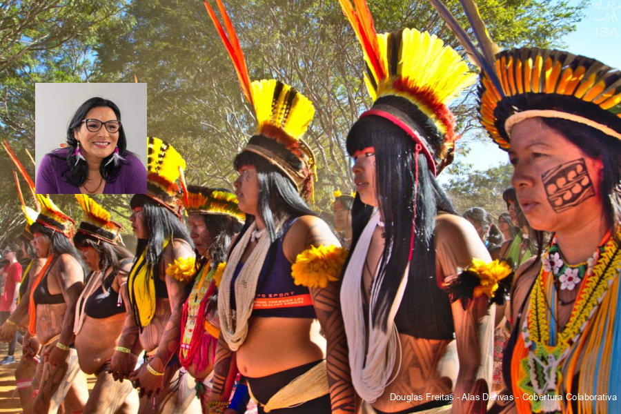 Mulheres indígenas perfiladas e paramentadas dançam e cantam