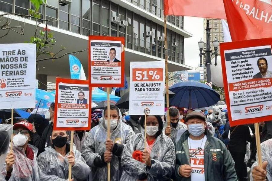 Servidores em greve portam cartazes contra o voto favorável de vereadores pela diminuição das aposentadorias 