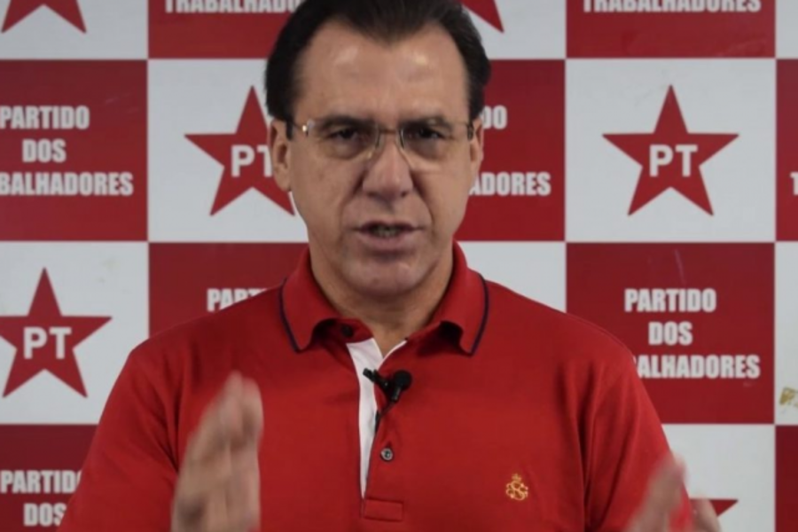 Foto de Luiz Marinho, presidente do PT SP, de camisa vermelha. Ao fundo, um mosaico de estrelas vermelhas do Partido dos Trabalhadores