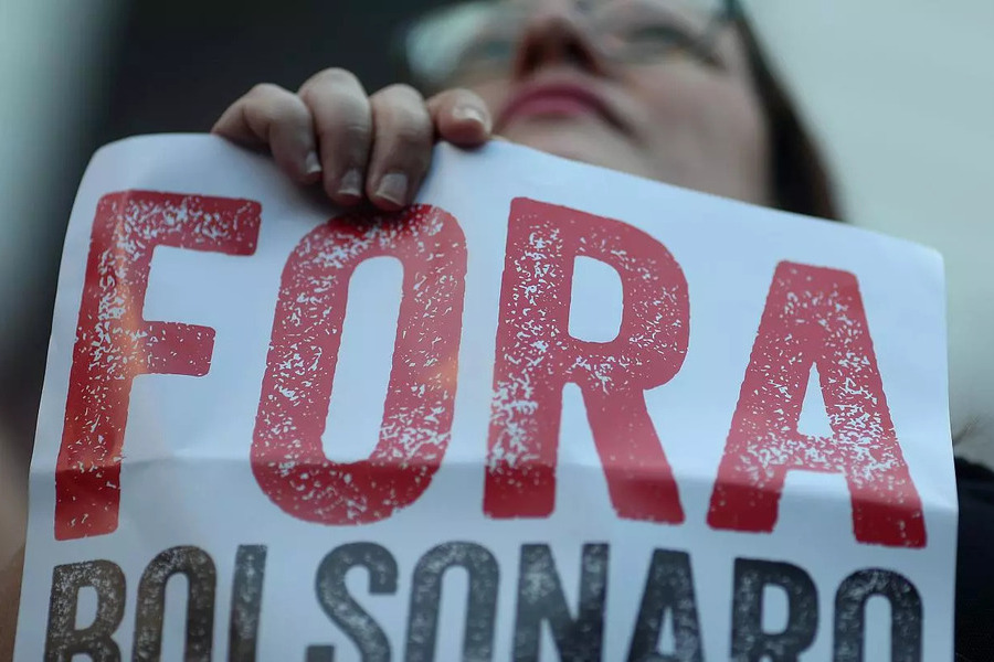 Mulher segura cartaz com a inscrição Fora Bolsonaro