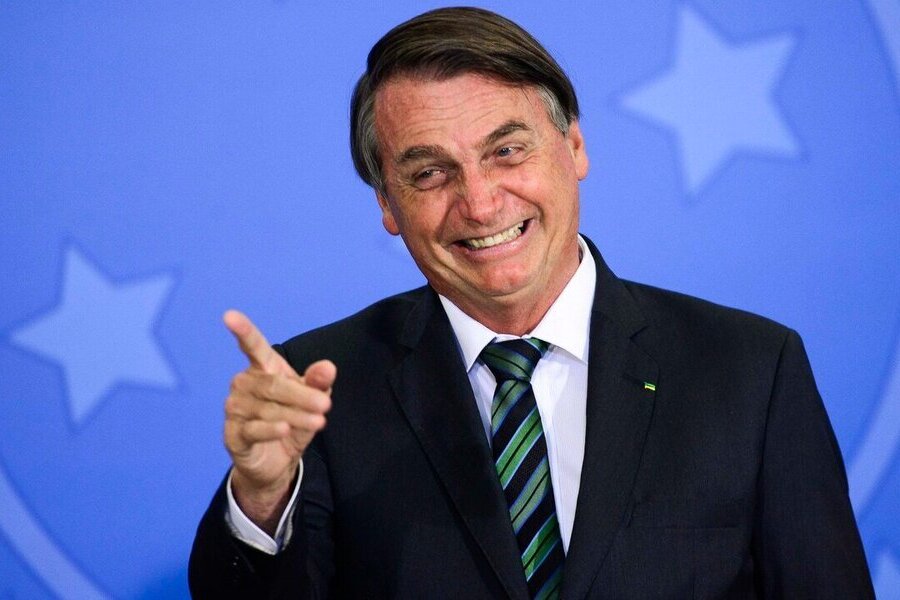 Foto de Bolsonaro rindo e apontando o dedo para alguém