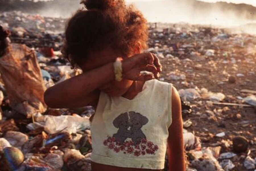 Criança faminta chora em meio ao lixão