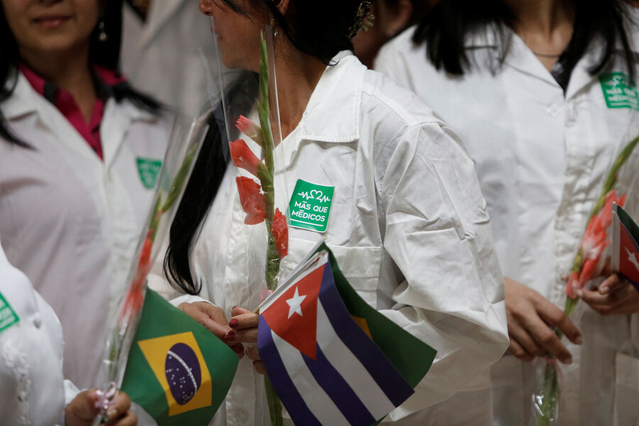 Médicos cubanos seguram as bandeiras de Cuba e do Brasil