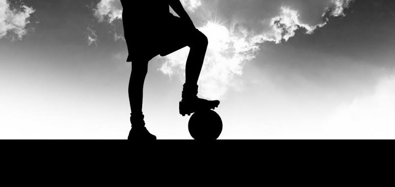 Imagem de um garoto posando um o pé em cima da bola