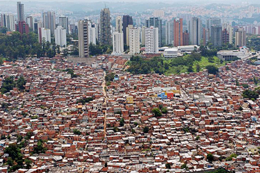 Foto aérea mostra um mar de prédios da linha do horizonte e uma praia imensa de casas da periferia da cidade de São Paulo
