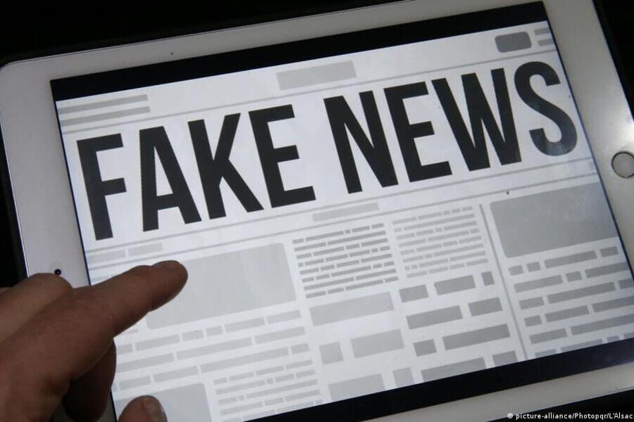 Foto ilustração de uma pessoa navegando sobre uma publicação eletrônica, cujo título está escrito com letras grandes; Fake News