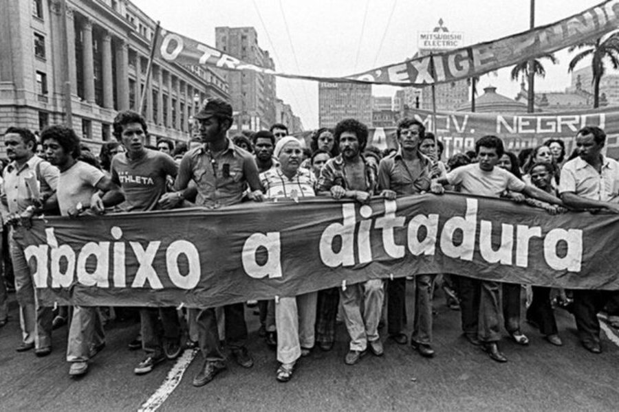 Grupo de trabalhadores caminham com faixa pedindo "Abaixo a Ditadura".