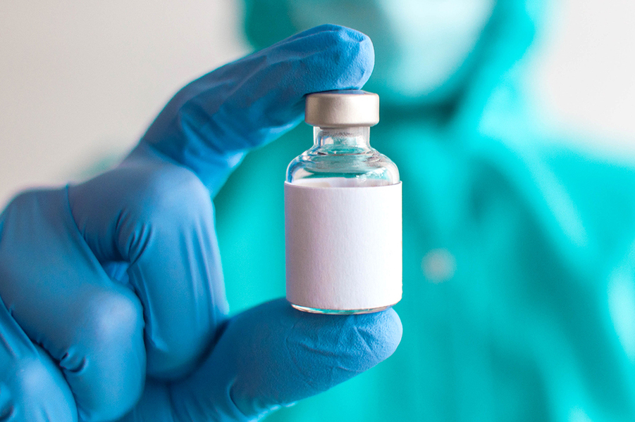 Médico segura um frasco de vacina sem identificação