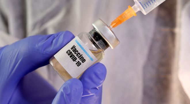 foto em close de uma seringa espetada em uma ampola de vacina