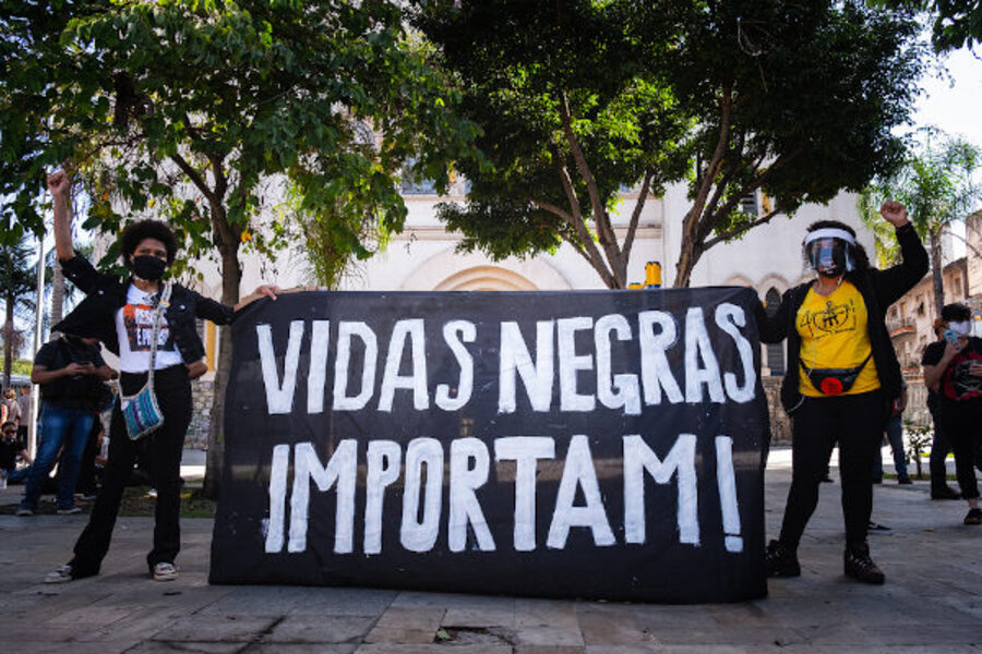 Duas manifestantes portam uma faixa com a inscrição "Vidas Negras Importam"
