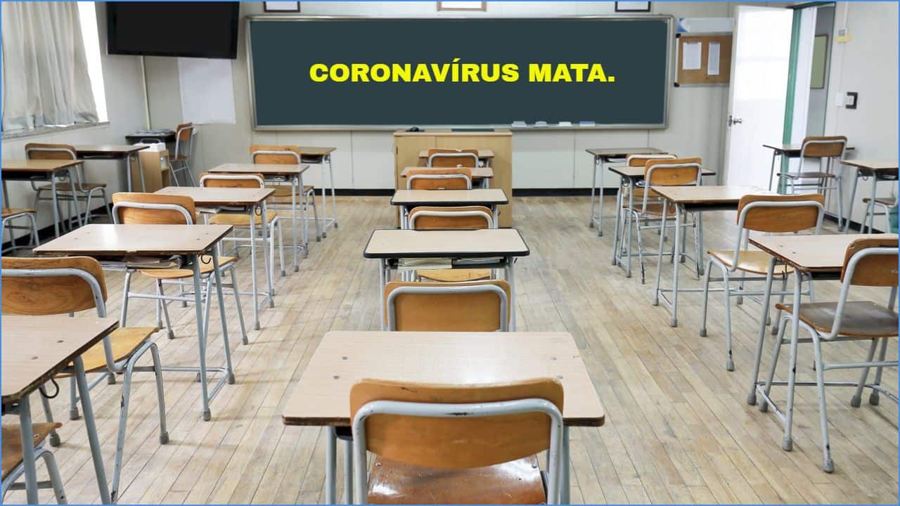 Dos fundos da sala de aula vazia, quadro negro escrito "coronavírus mata"